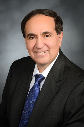 Frank Chervenak, MD, wearing a blue tie and striped suit